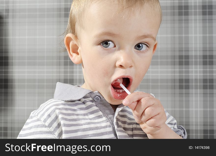 Boy eating his lollipop with mouth wide open. Boy eating his lollipop with mouth wide open