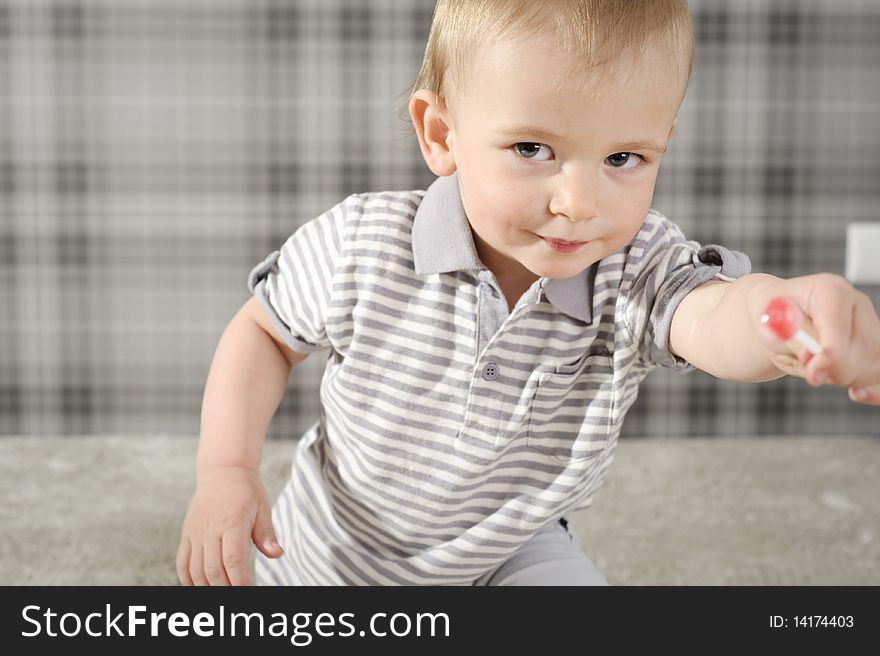 Boy eating his lollipop with mouth wide open. Boy eating his lollipop with mouth wide open