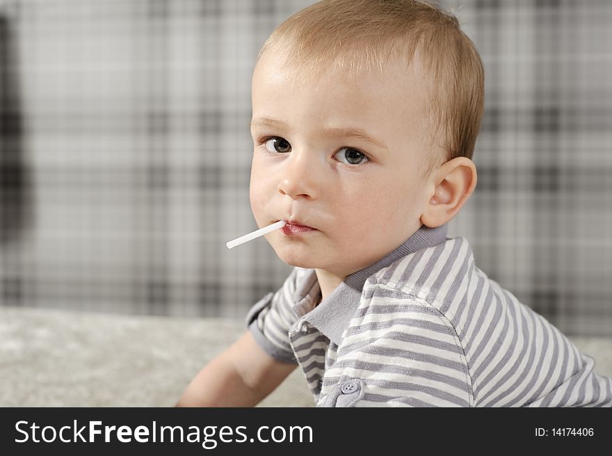 Little boy eating his lollipop and looking at the camera. Little boy eating his lollipop and looking at the camera