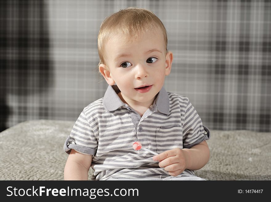 Little boy eating his lollipop and smiling. Little boy eating his lollipop and smiling