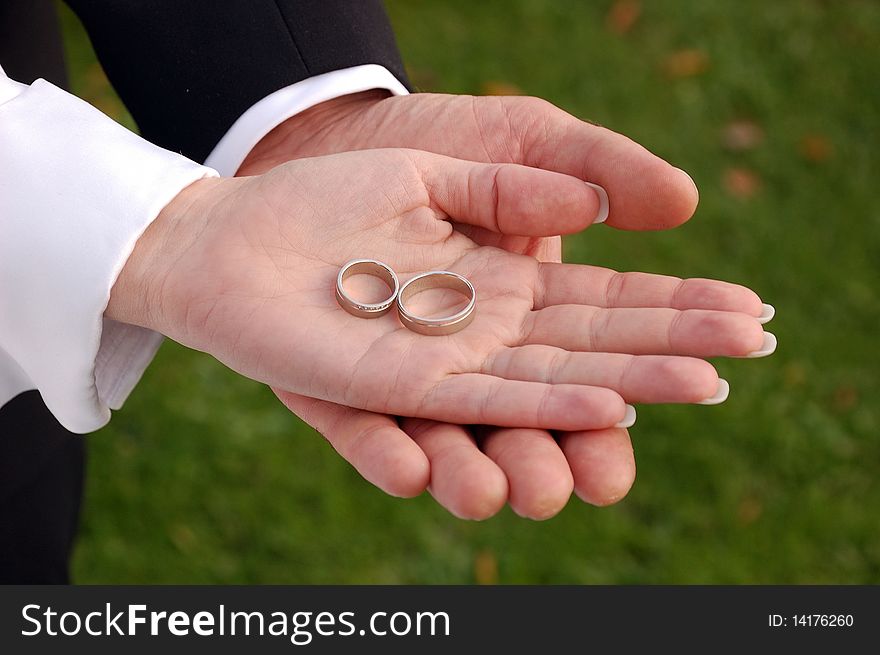 Bride and groom showing their wedding rings on their palms