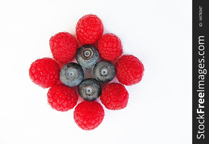 Detail of raspberries and blueberries against white background