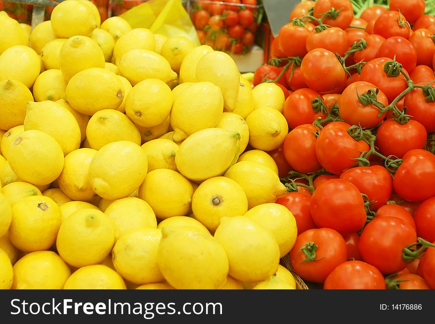 Close up of big lemons and tomatoes on market stand