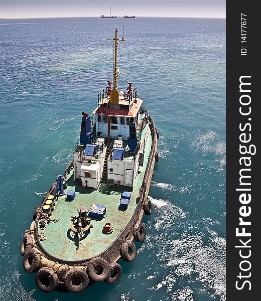 Tug boat working sailing vessel on sea