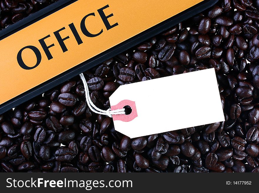 Coffee grains as a background on them the tablet with an inscription Office and pure label.