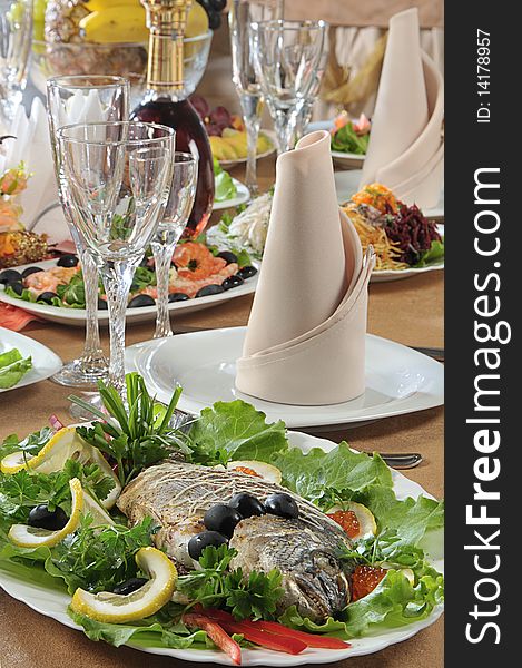 Table served in a restaurant with fish on a foreground. Table served in a restaurant with fish on a foreground
