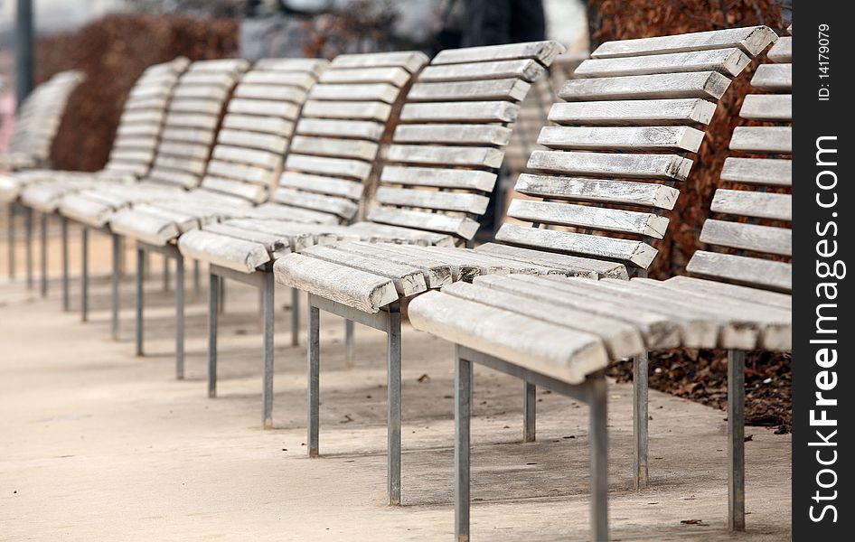 Row of the white wooden benches. Row of the white wooden benches