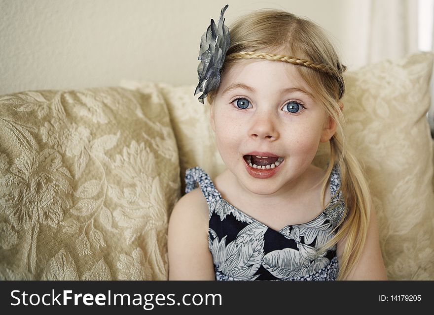 Little girl looking at camera wearing flower hair clip making a funny face. Little girl looking at camera wearing flower hair clip making a funny face