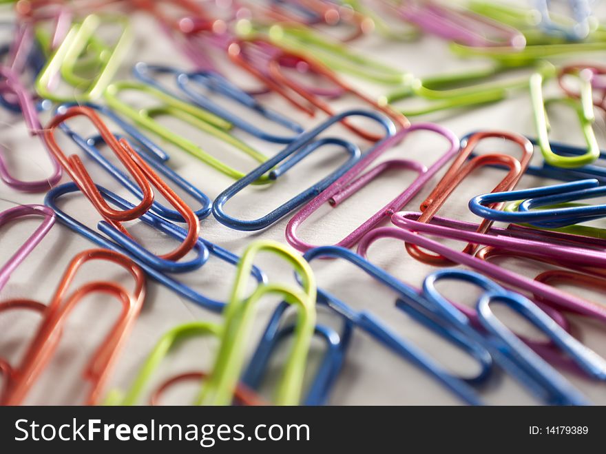 Colorful paper clips on a white piece of paper.