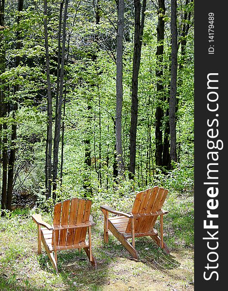 Two Adirondack chairs near a bluff over looking the woods below. Two Adirondack chairs near a bluff over looking the woods below.