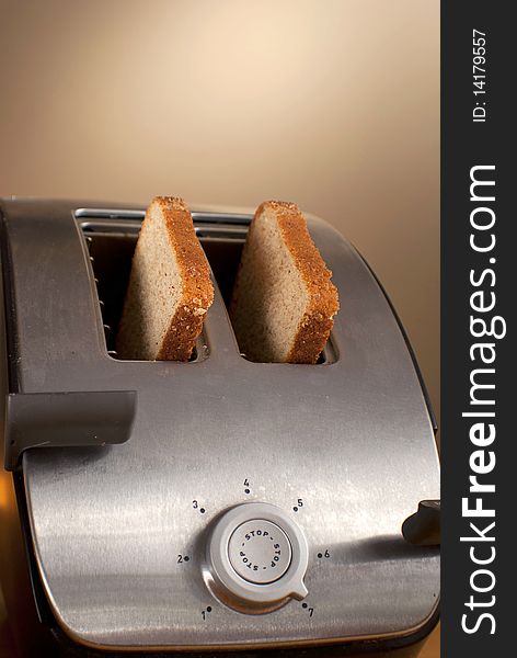 Two pieces of wheat bread sit in a toaster. Two pieces of wheat bread sit in a toaster.