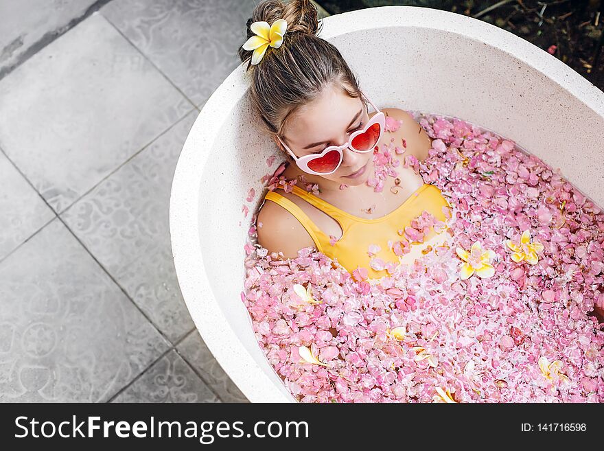 Girl Relaxing In Spa Bath With Flowers