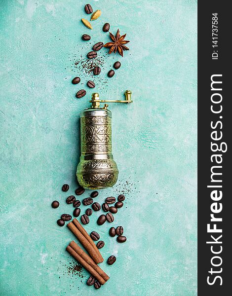 Top view of vintage manual coffee grinder, coffee beans and spices, space for text, blue background. Top view of vintage manual coffee grinder, coffee beans and spices, space for text, blue background