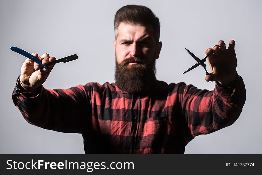 Bearded man, long beard, brutal, caucasian hipster with moustache. Barber scissors and straight razor, barber shop. Male