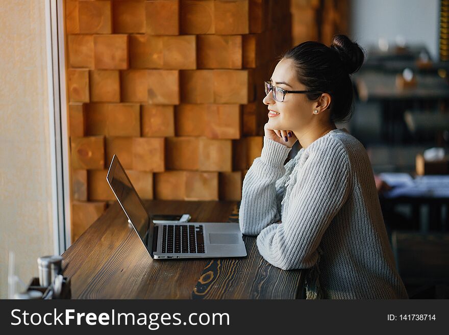 Brunetter woman working on her laptop at a restaurant. Brunetter woman working on her laptop at a restaurant