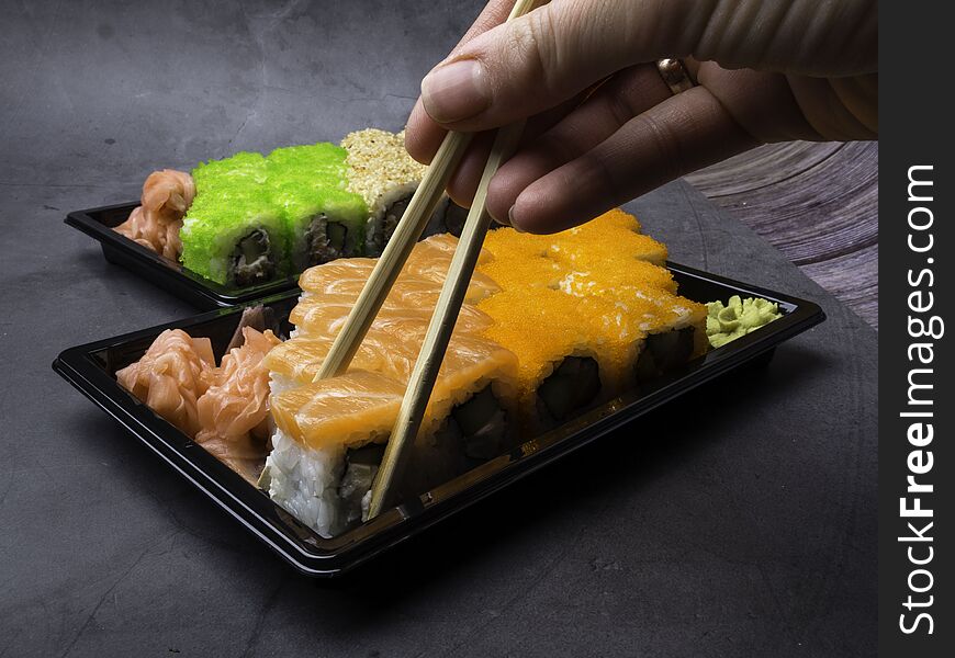 Japanese sushi on a dark background. Sushi rolls, pickled ginger, wasabi. Sushi set on a table. Space for text. sushi background. Asian or Japanese food