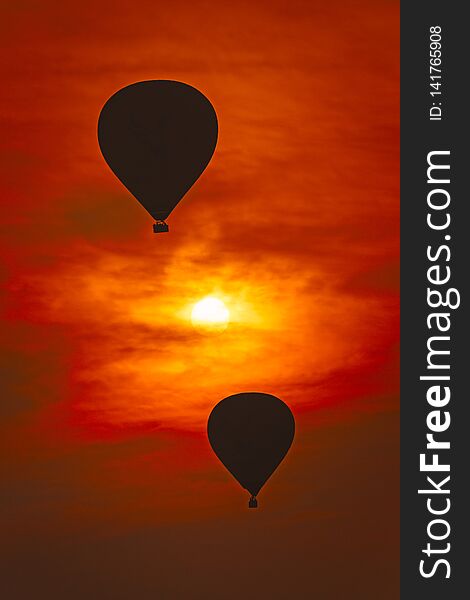 2 air balloons against red sky and the sun is in between. 2 air balloons against red sky and the sun is in between.