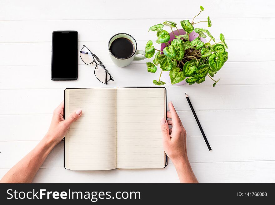 Top view of girl holding notebook with background composition on white table. Top view of girl holding notebook with background composition on white table