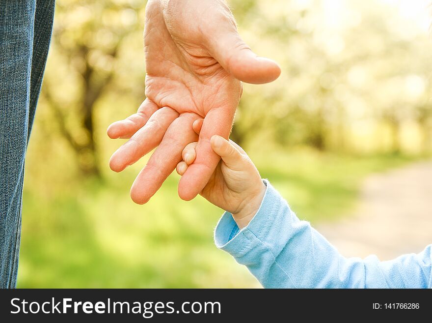 The parent holding the child`s hand with a happy background
