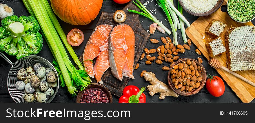 Healthy food. Salmon steaks with honey and organic food . On black rustic background