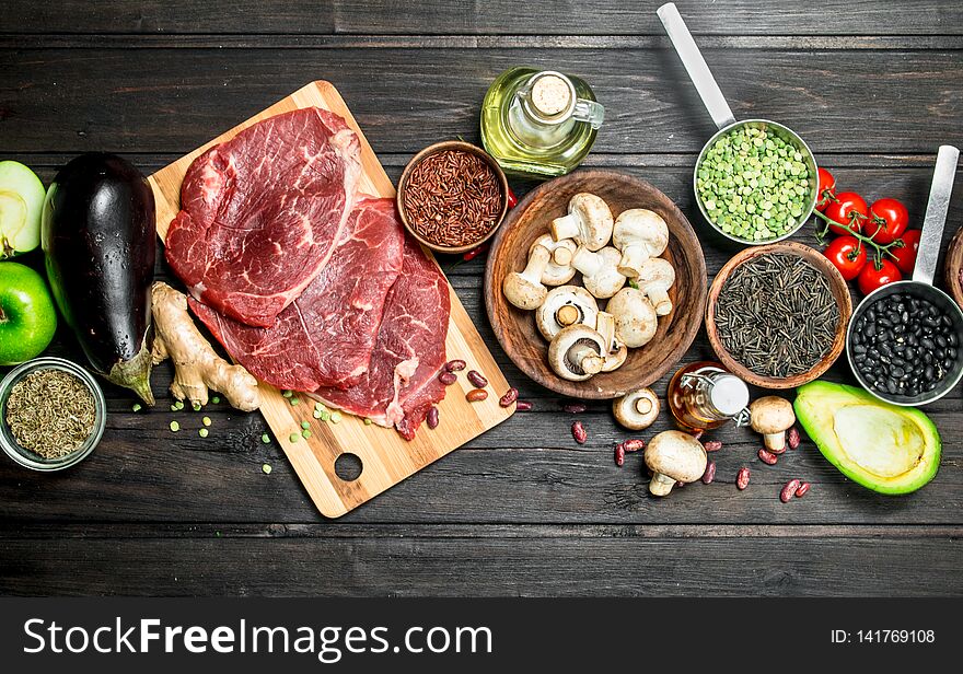 Healthy food. Raw beef with a variety of organic food and spices. On a wooden background