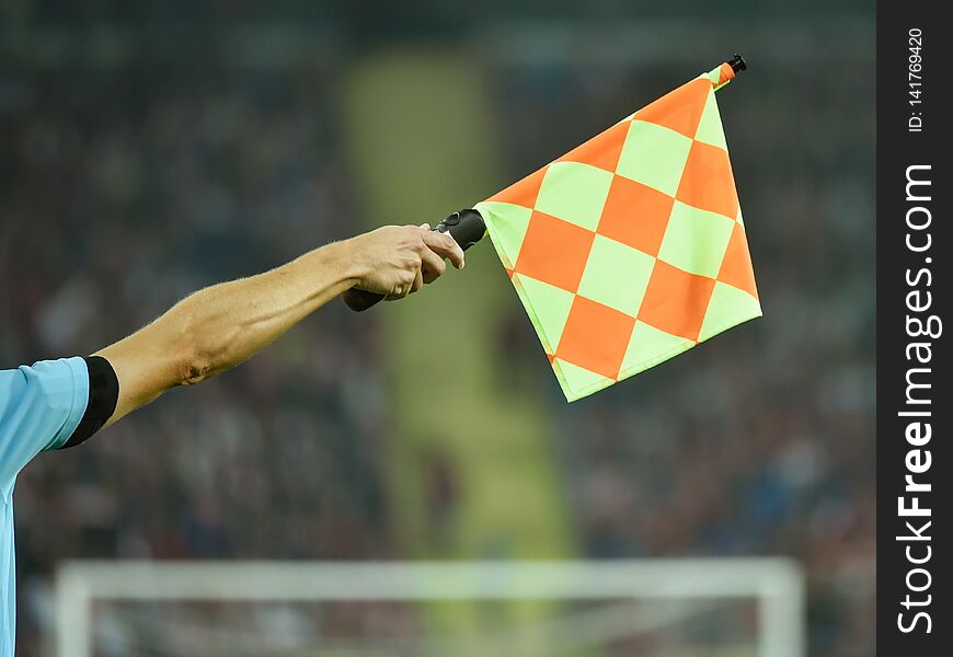 Raised hand with flag of assistant soccer referee