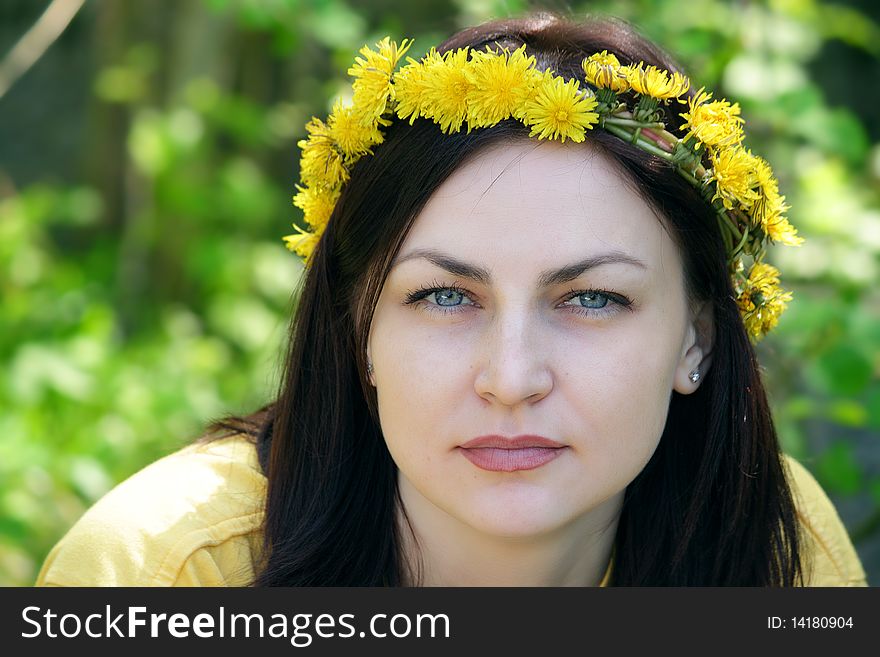 Wreath on a head of the girl sitting in a wood