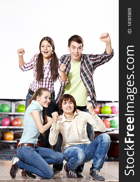 Young attractive people rejoice at game in bowling. Young attractive people rejoice at game in bowling