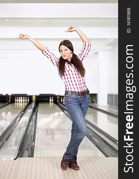 The young girl rejoices to a successful throw in bowling. The young girl rejoices to a successful throw in bowling