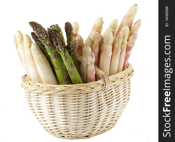 Fresh asparagus in basket, seasonal vegetables in the spring before white background