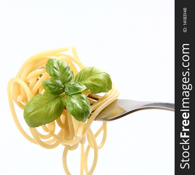 Spaghetti with basil leaves on a fork