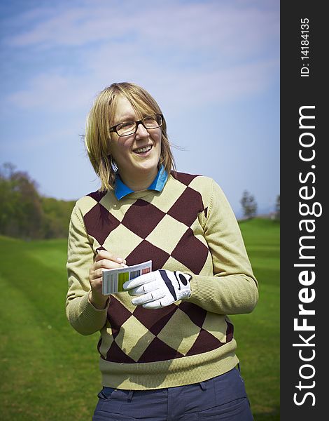 Golfer woman writing handicap and smiling.