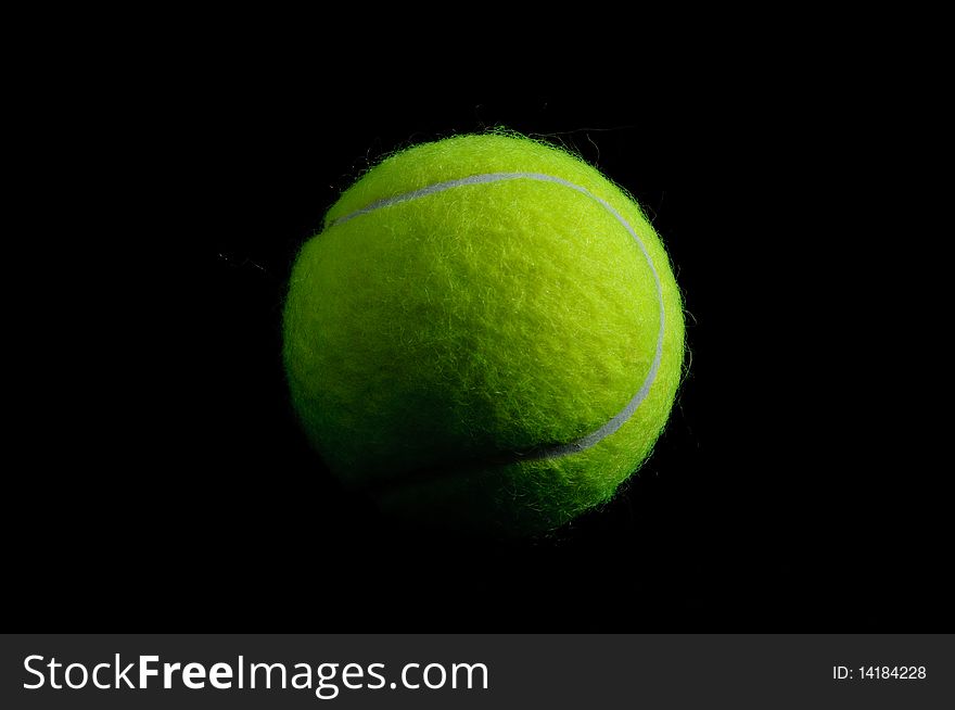 Yellow tennis ball on black background