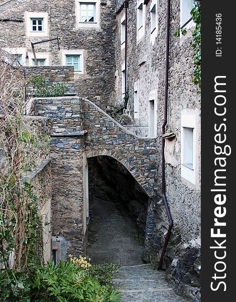 Small stone village entrance with stairs going down and coloured windows, Italy. Small stone village entrance with stairs going down and coloured windows, Italy