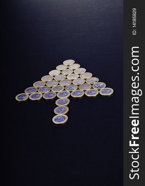 This image depicts a group of coins, arrow-shaped, indicating a direction. This image depicts a group of coins, arrow-shaped, indicating a direction