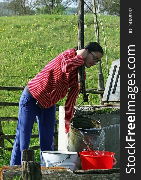 Cute girl pouring water from a bucket to another