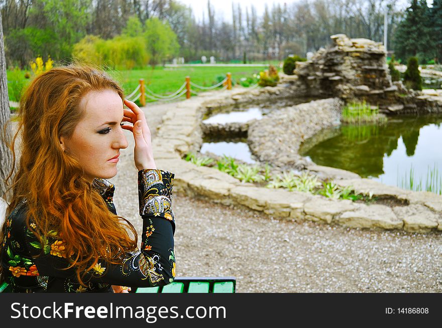 Red head girl thinking in the park,emotional