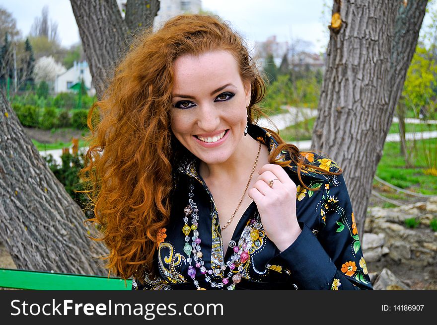 Red head girl smiling in the park,emotional