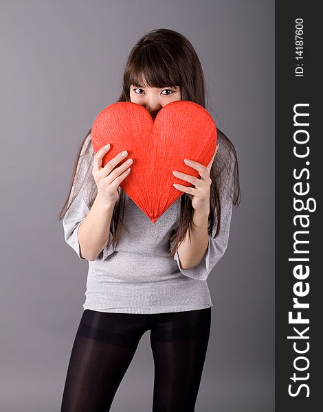 Beautiful woman holding red heart studio shot