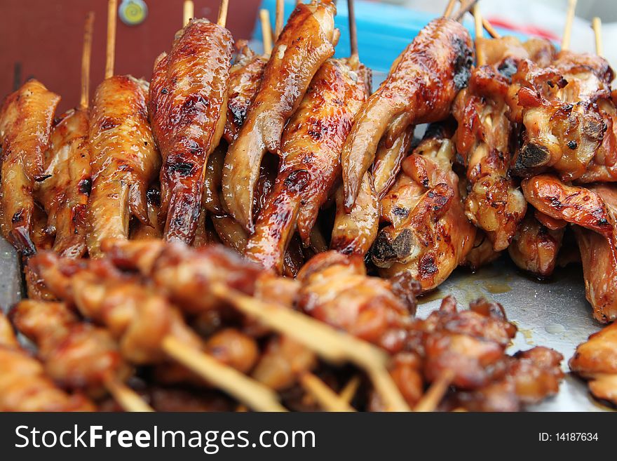 A street food stall selling grilled chicken in Bangkok. A street food stall selling grilled chicken in Bangkok