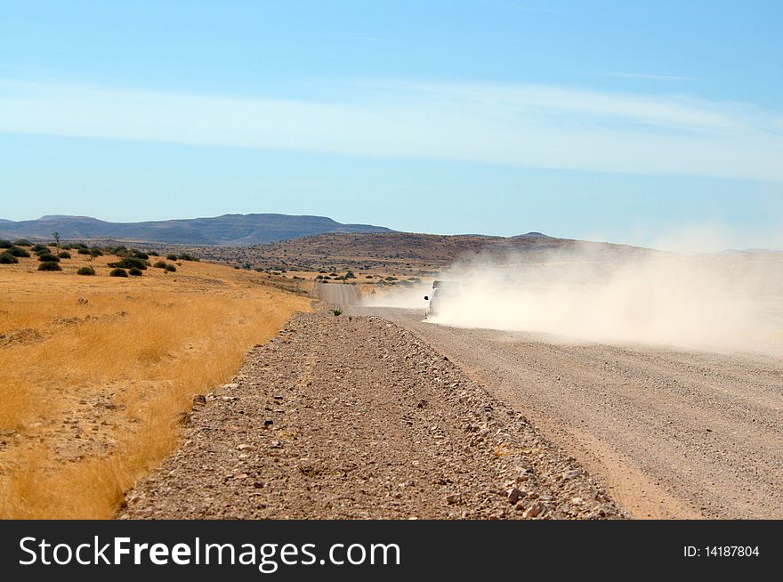 Cars causing dust on road through Namibia. Cars causing dust on road through Namibia.