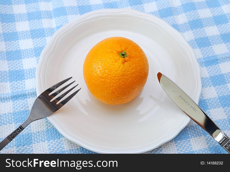 Fork and knife ready to eat orange on plate. Healthy eating and lifestyle, diet and nutrition, and fresh fruit concepts . Fork and knife ready to eat orange on plate. Healthy eating and lifestyle, diet and nutrition, and fresh fruit concepts .