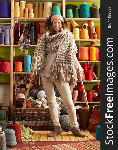 Woman Wearing Knitted Scarf Standing In Front Of Yarn Display