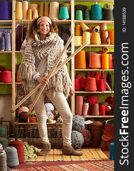 Woman Wearing Knitted Scarf Holding giant needles