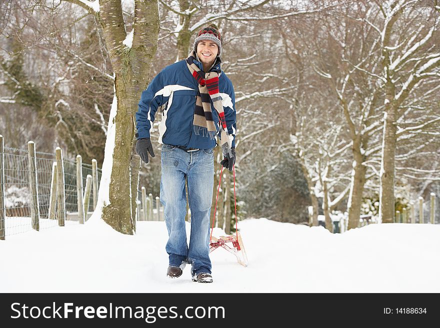 Man Pulling Sledge Through Winter Landscape