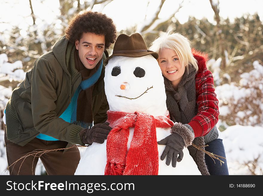 Teenage Couple Havin fun Building Snowman. Teenage Couple Havin fun Building Snowman