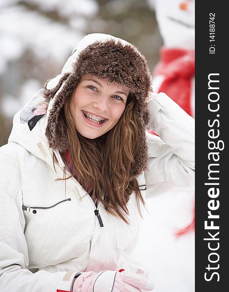 Teenage Girl Wearing Winter Clothes In Snowy Landscape