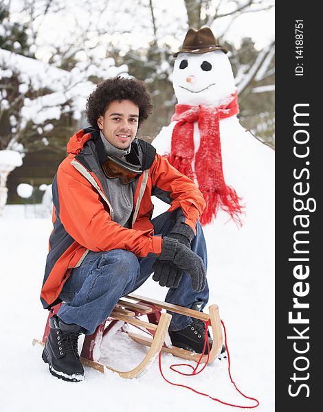 Smiling Man With Sledge Next To Snowman