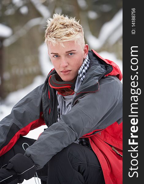 Teenage Boy Wearing Winter Clothes In Snowy Landscape Looking At Camera