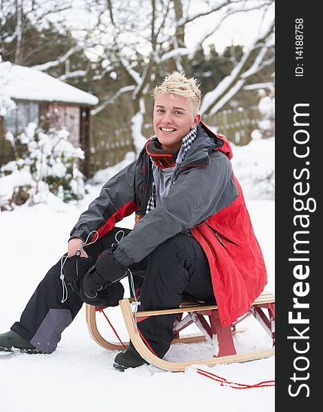 Teenage Boy With Sledge Smiling At Camera